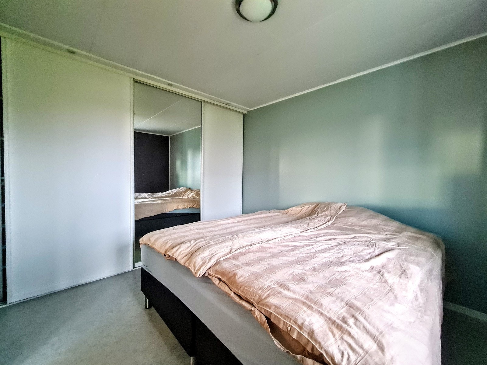 Del av soverom med skyvedørsgarderobe Galleribilde