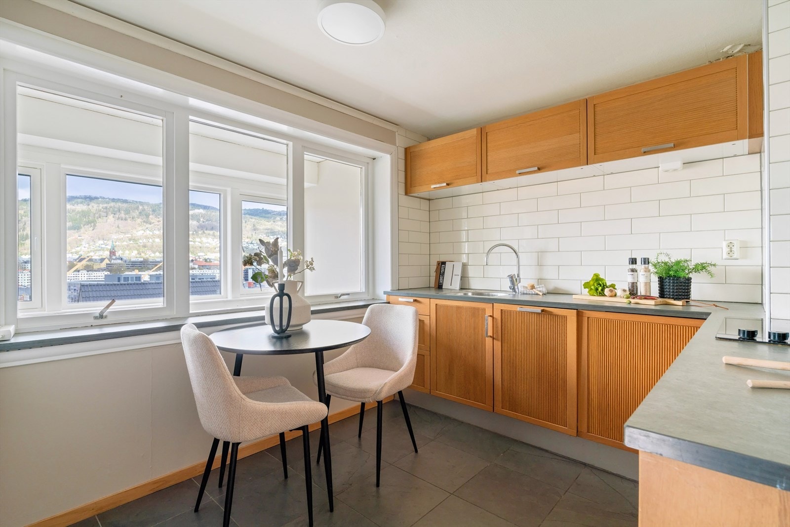 Kjøkken med innredning fra Ikea med profilerte fronter og benkeplate i stein. Galleribilde