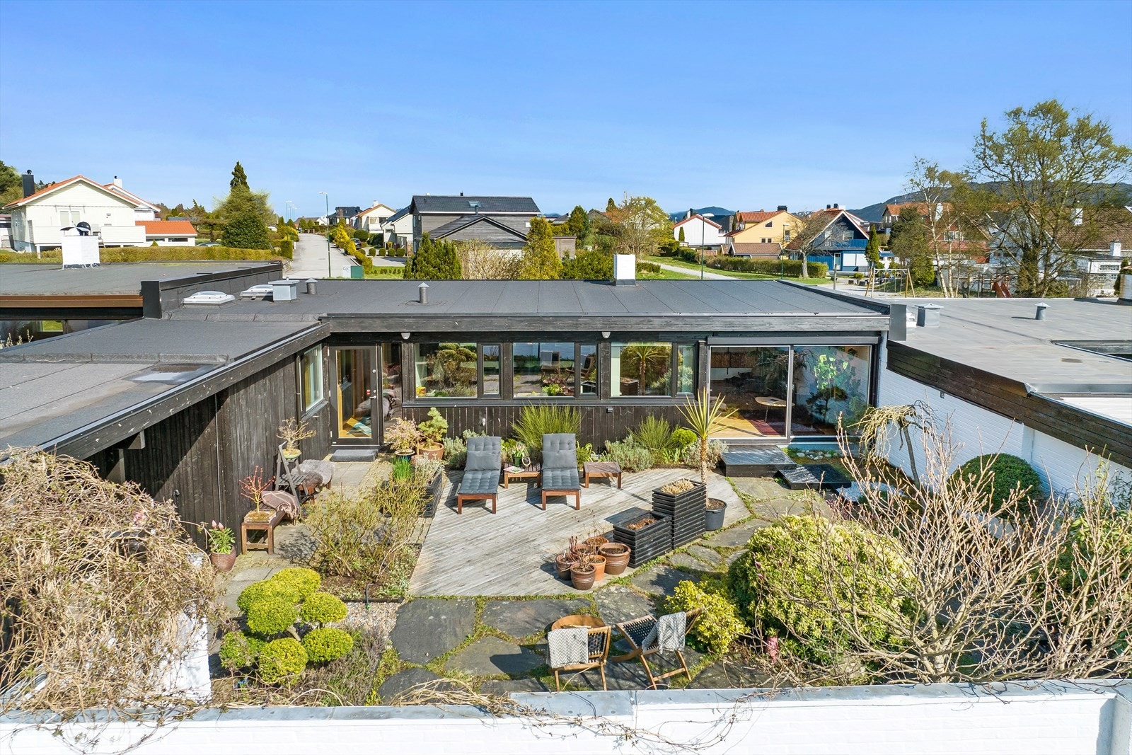 Den er vakkert opparbeidet med blomster, prydbusker, trær og terrasse. Galleribilde