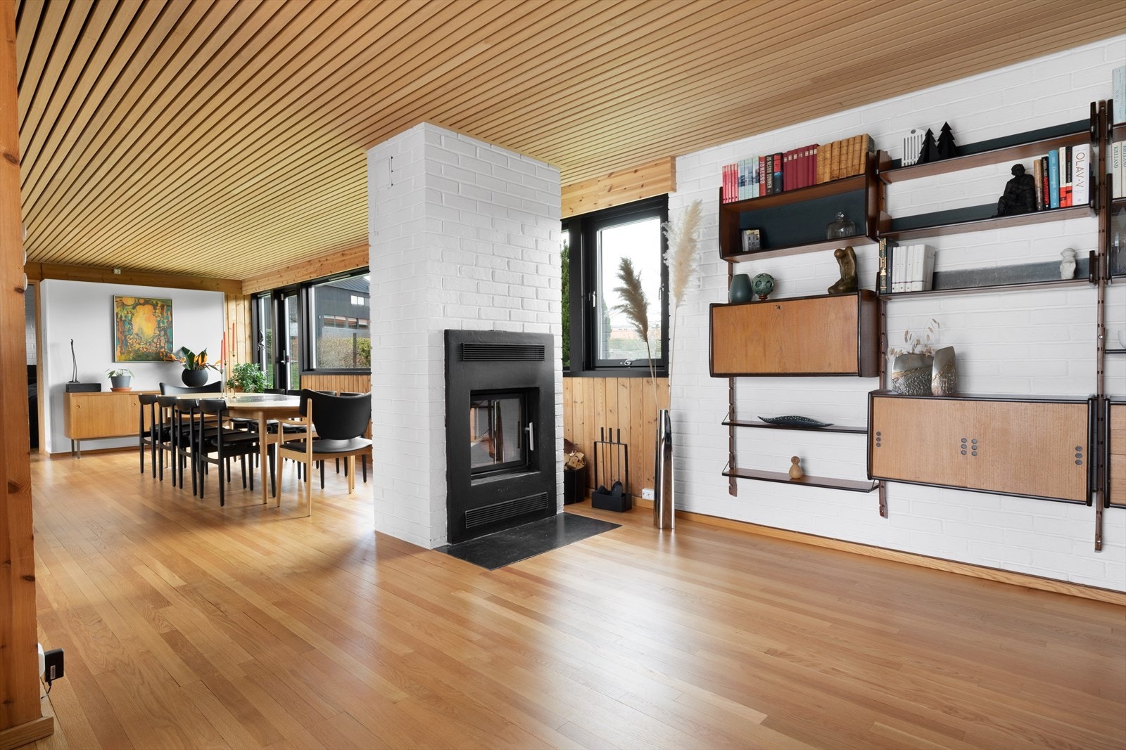 Den flotte gjennomgående peisen fungerer som en skillevegg mellom stuen og spisestuen. Galleribilde