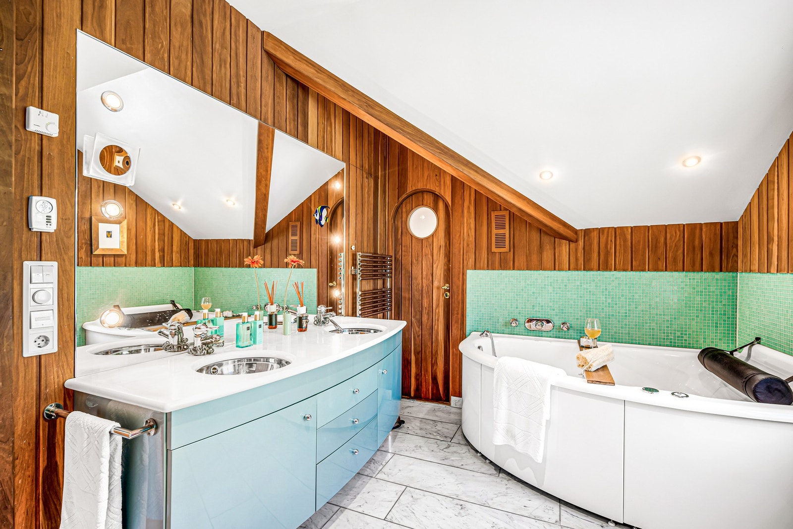 Jacuzzi boblebad fra Svedberg med luft, vanndyser og lys. Baderomsinnredning fra Thomas Katrein i Berlin. Benkeplate i Thassos marmor (gresk) med 2 innfelte runde servanter. Rund dør med koøye inn til soverommet. Galleribilde