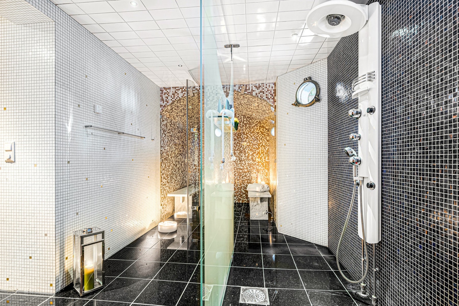 Mellom badstu og dampbad, er det en stor dusj med skillevegg i herdet, melkehvitt glass. Galleribilde