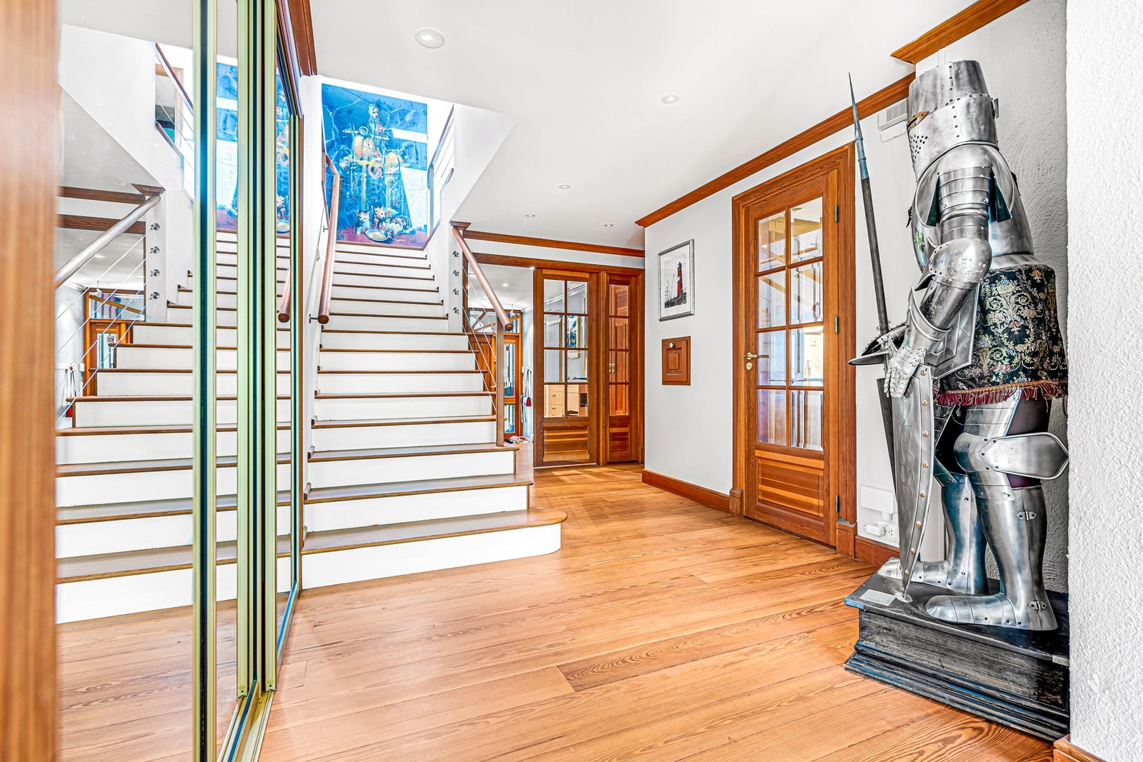 Inngang fra vindfang/gang til stue, kjøkken og trapp til 2. etg. og med romslig garderobe bak bronsespeilene til venstre. Galleribilde