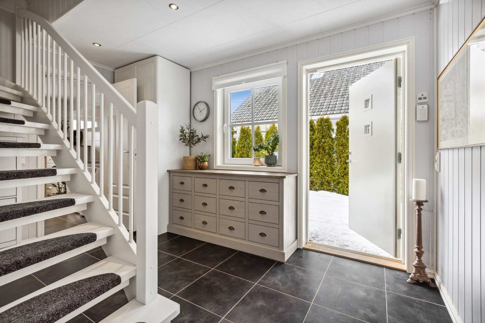 Innbydende entré med downlights i himling, flislagt gulv med varmekabler og plass til oppbevaring av yttertøy og sko. Galleribilde