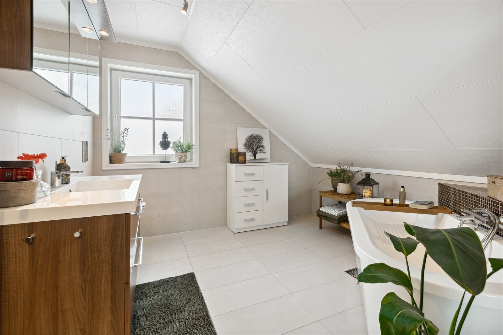 Videre inneholder badet veggmontert toalett og servantinnredning med skuffer og speilskap. Galleribilde