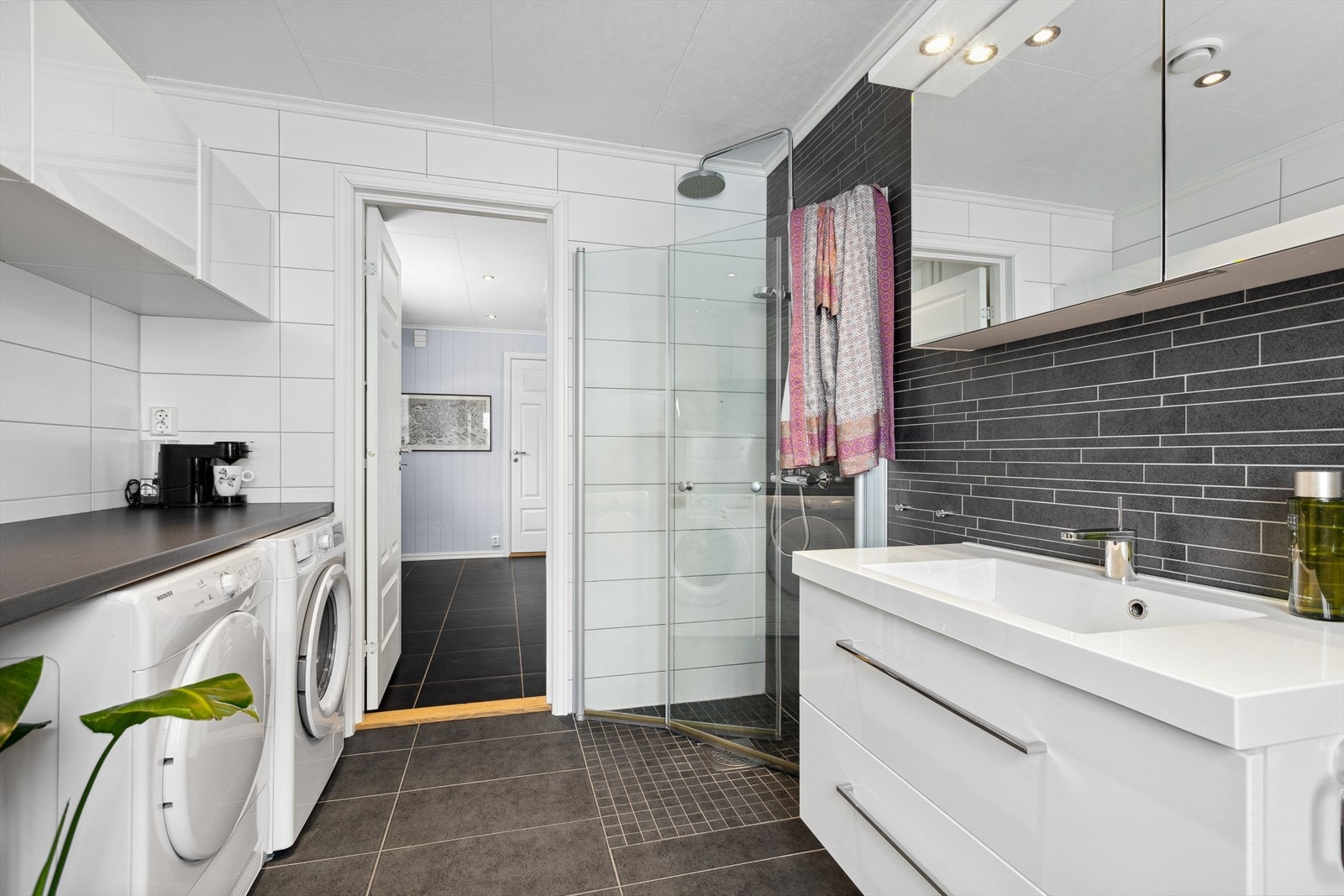 Badet har også en romslig benkeinnredning med overskap og opplegg for vaskemaskin. Galleribilde