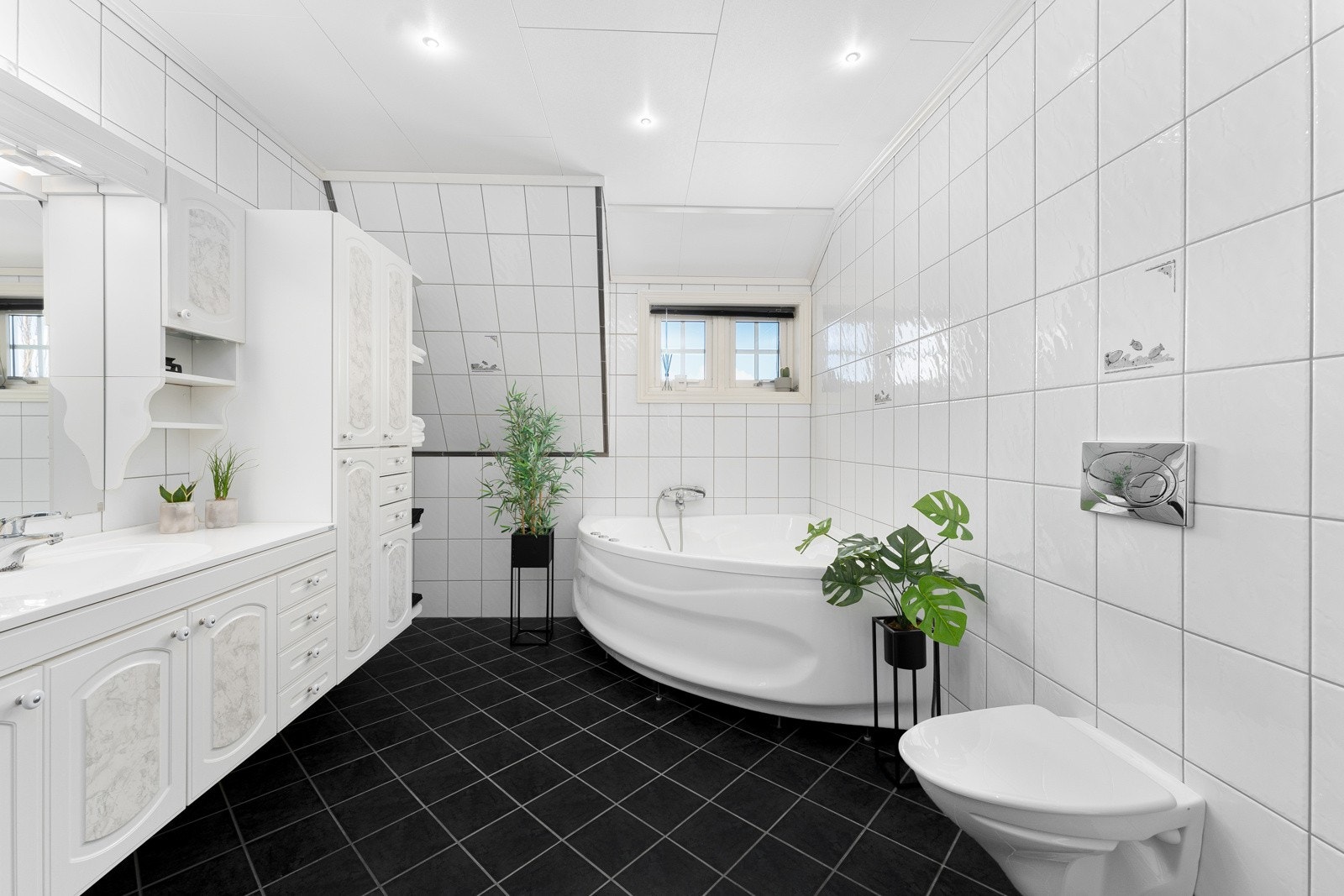 Flislagt bad med både vegghengt wc, badekar, dusj og dobbel vask Galleribilde