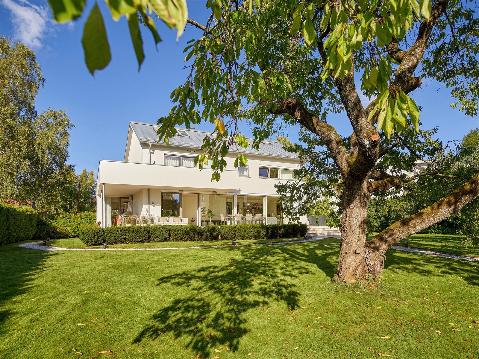 Den store tomten er pent opparbeidet med gressplen, gangveier, lys og beplantning. Galleribilde