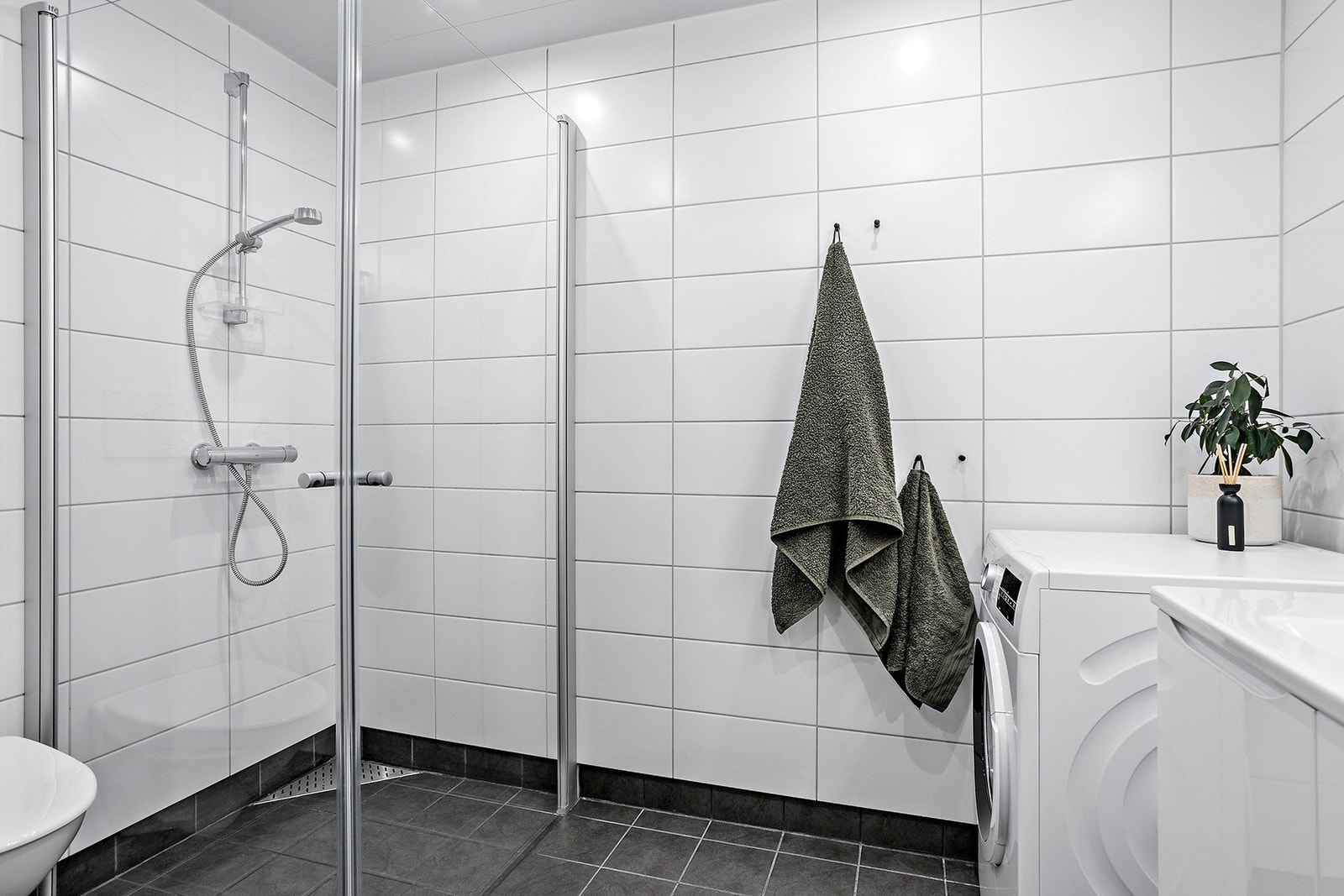Badet er flislagt med gulvvarme, innfellbare dusjdører og opplegg til vaskemaskin. TG0. Galleribilde
