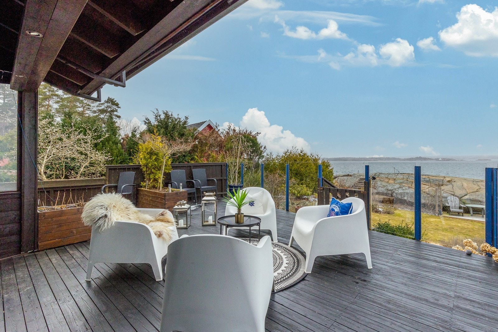 Høyt rekkverk i glass gir uhindret utsikt og le for vind. Dele av terrassen er overbygd. Galleribilde