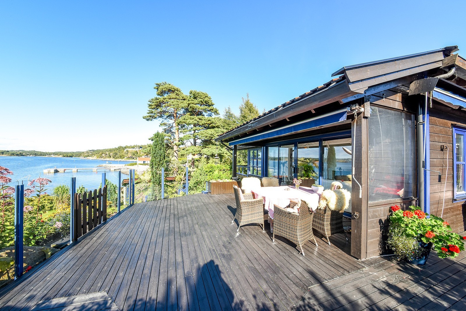 En stor terrasse strekker seg langs nordvest og sørvest, med adkomst fra både stuen og inngangspartiet. Galleribilde