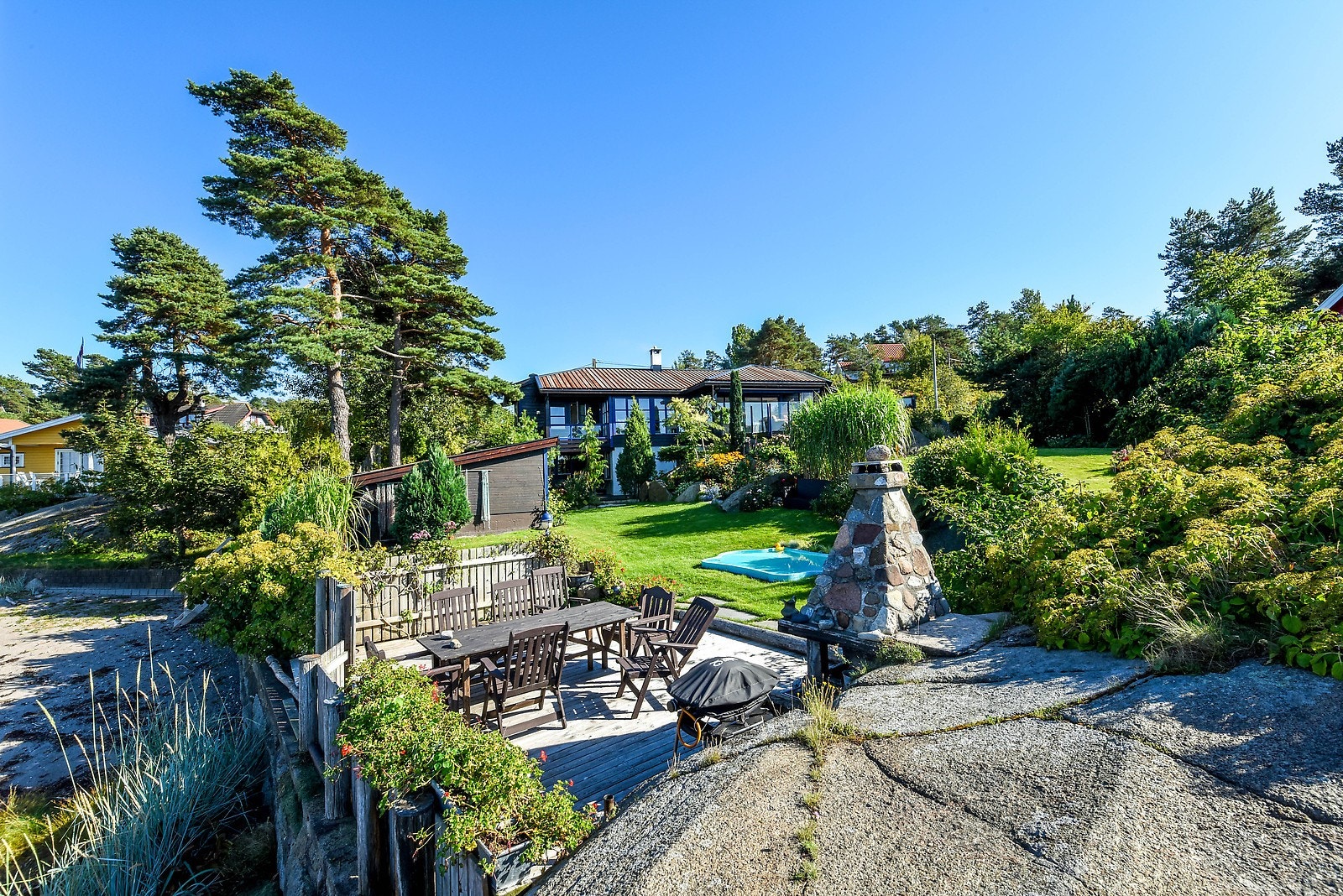 Eiendommen er flott opparbeidet og har svaberg, sandstrand og frodig hage med mye boltreplass. Galleribilde