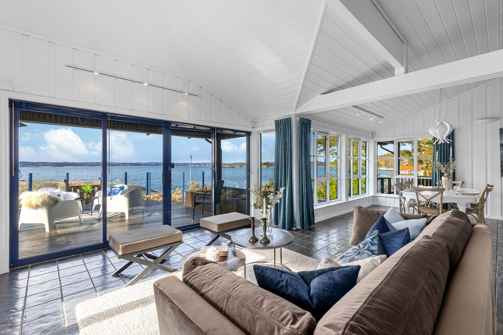 Brede skyvedører i glass åpner stuen ut mot terrassen. Galleribilde