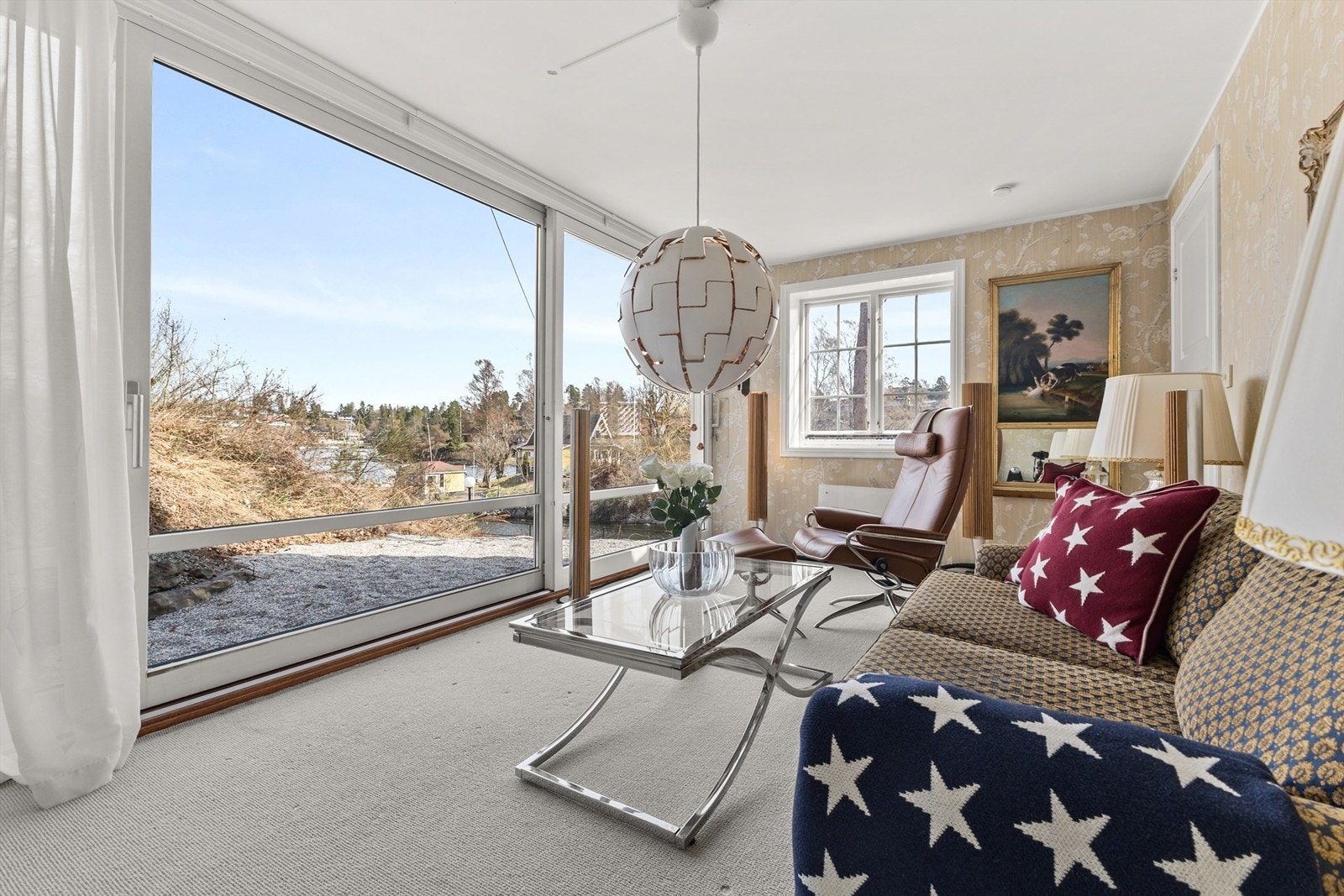Stue med plass til sofa og lenestol. I forkant av stuen er det store skyvedører som vender ut mot uteplassen. Herfra har du utsikt ned til fjorden. Galleribilde