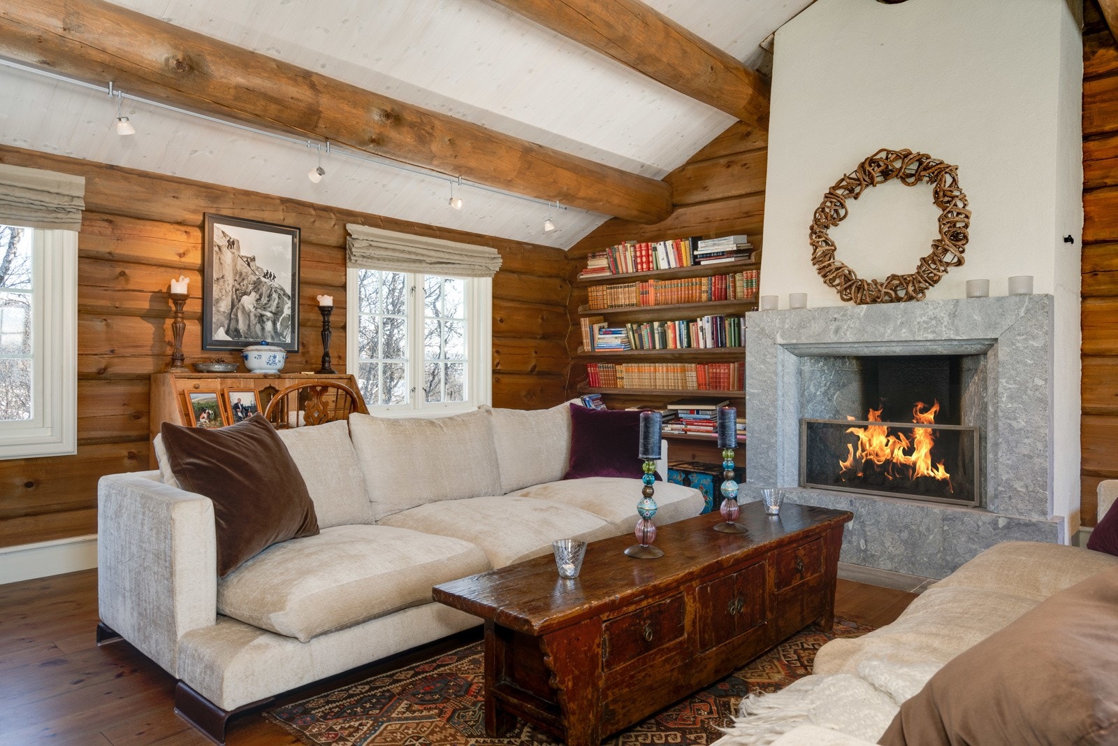 I midten av rommet pryder en stor åpen peis med kleberstein, som både er flott å se på, og som gir ekstra hygge og varme til rommet. Galleribilde