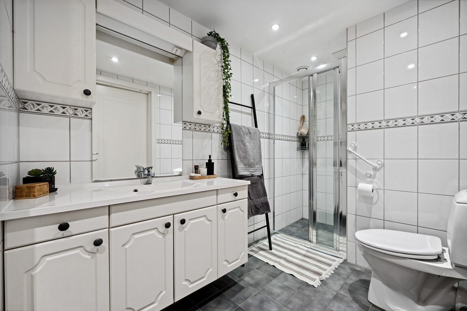 Flislagt baderom fra byggeår, med varmekabler i gulv og downlights i himling. Varmekabler og gulvfliser ble byttet i 2012. Galleribilde