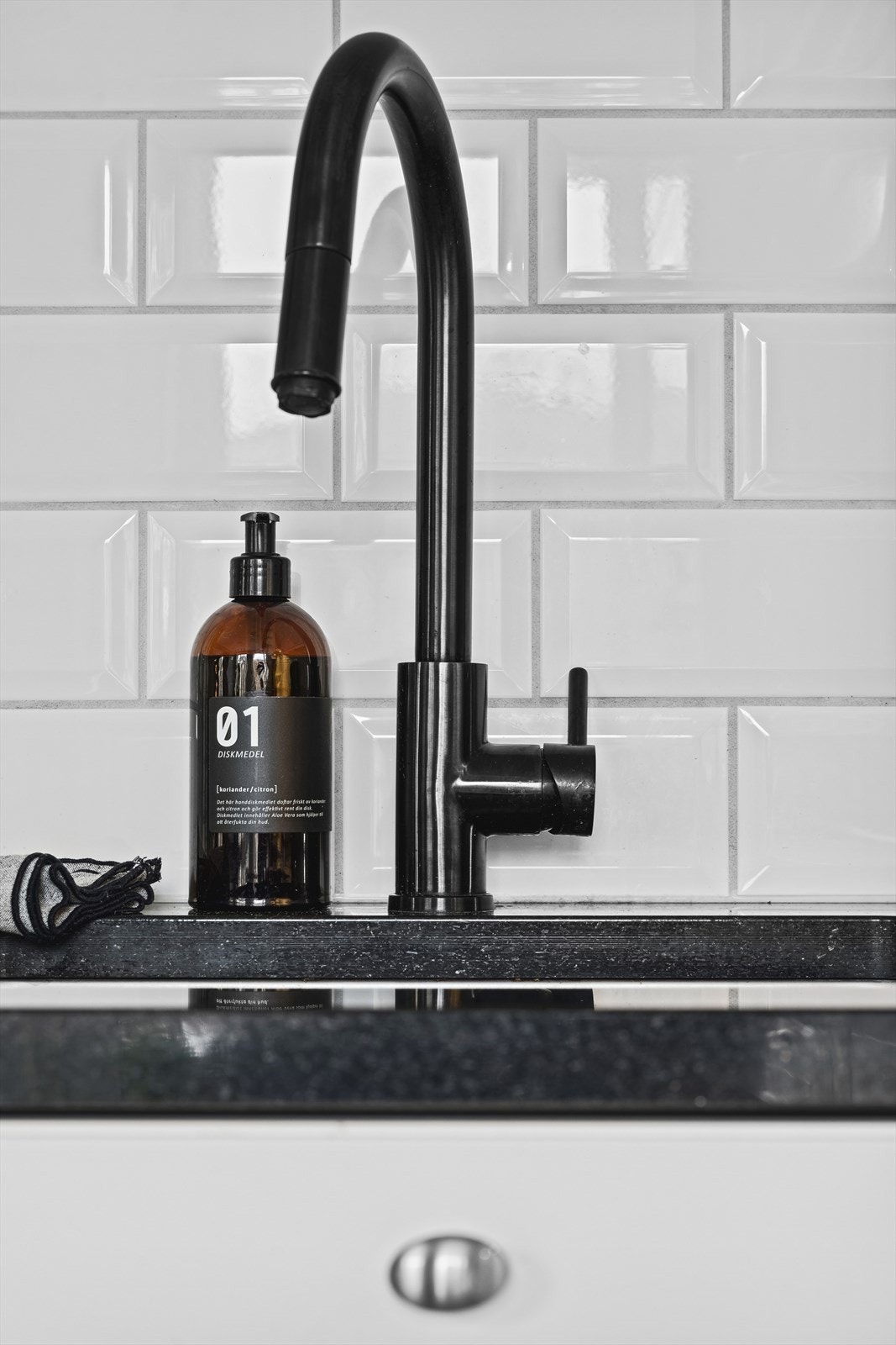 Eksklusiv sort granitt benkeplate med underlimt vask og sort blandebatteri. Galleribilde