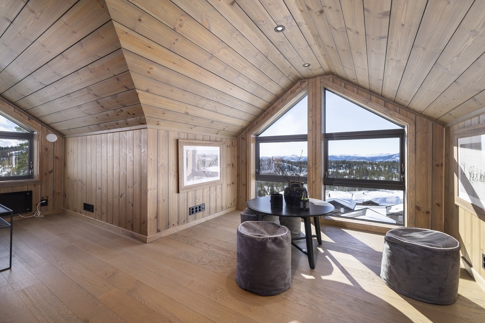 Store vindusflater i loftstuen gir mye naturlig lys inn, og rammer inn der vakre landskapet utenfor vinduet. Galleribilde