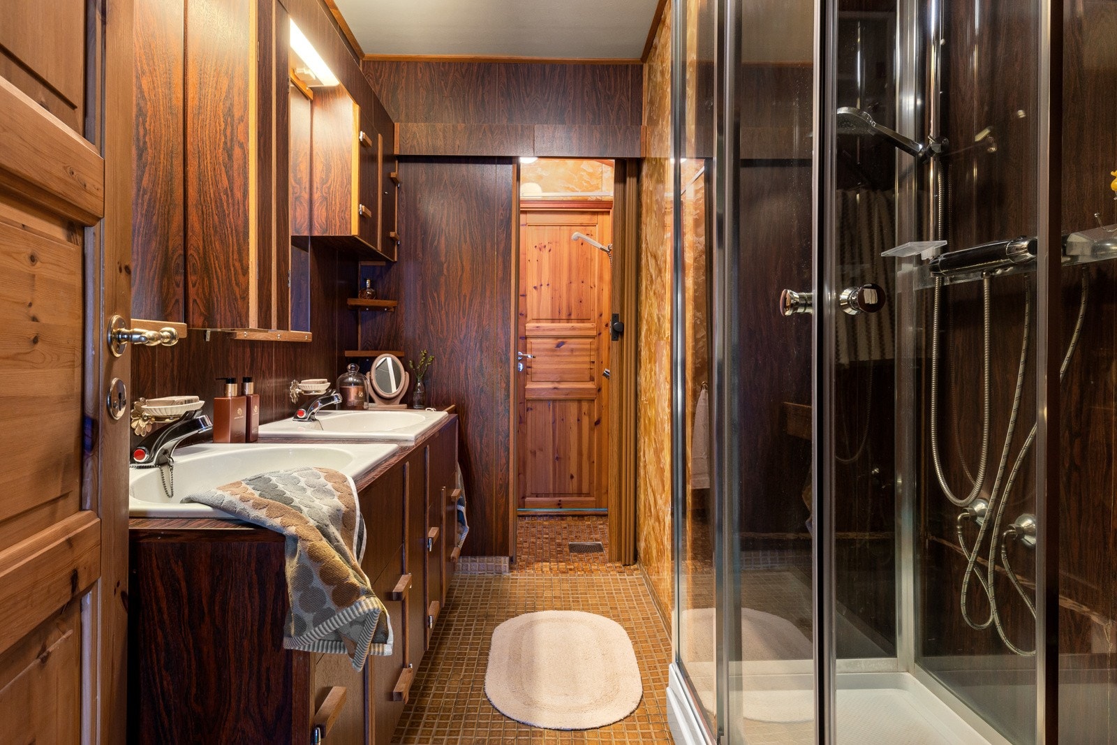 Badet i boligen er plassert midt i huset og inneholder dobbel vask med innredning, speil og dusj. Badet står foran renovering. Galleribilde
