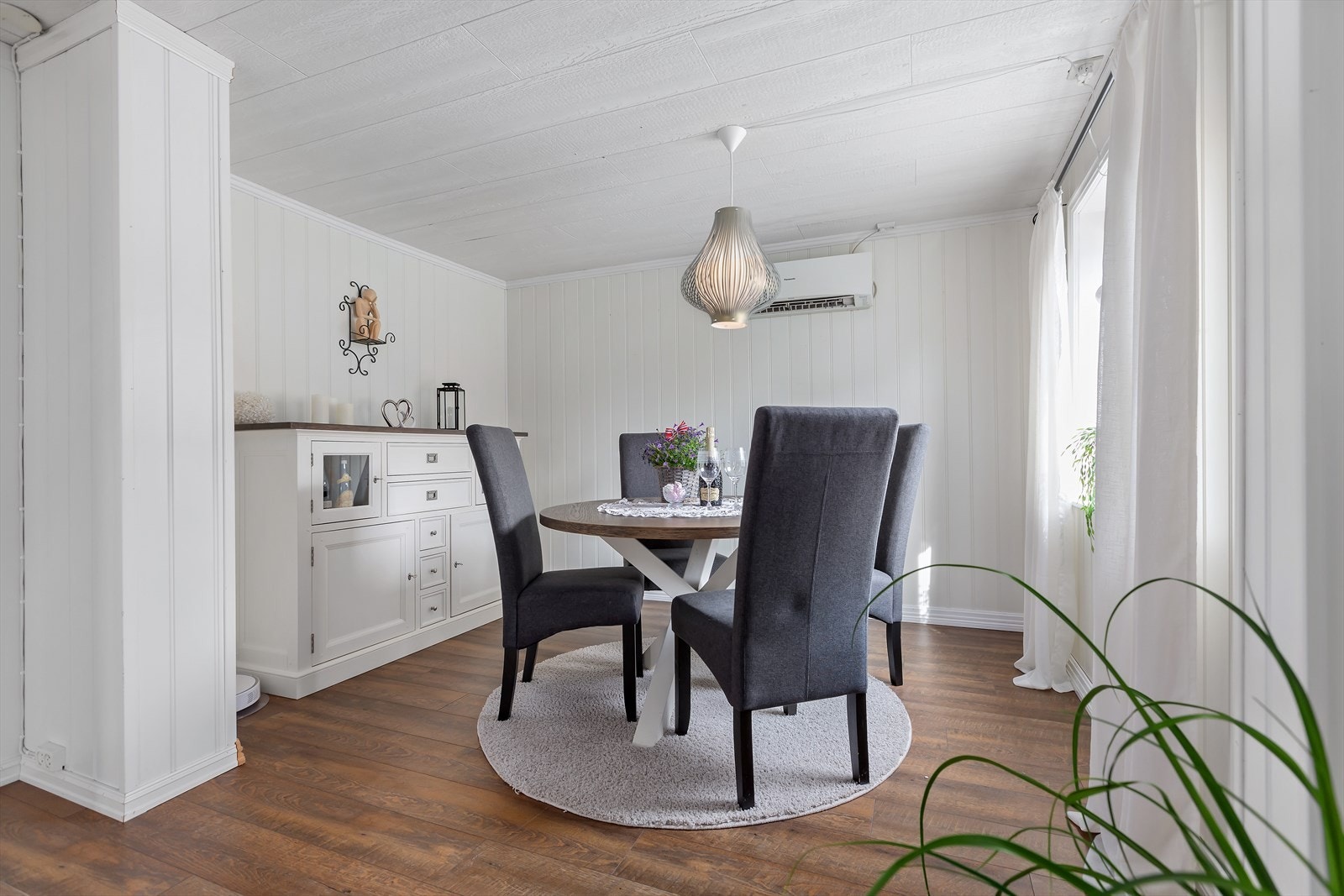 Plass for spisestue i del av stuen. Varmepumpe montert på veggen over spisebord. Galleribilde