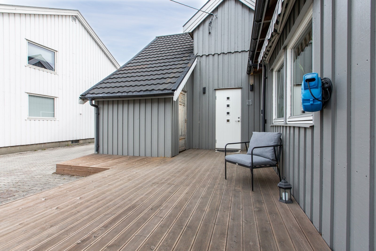Fin terrasse foran inngangen til boligen. Utebod ved siden av inngangsparti. Galleribilde