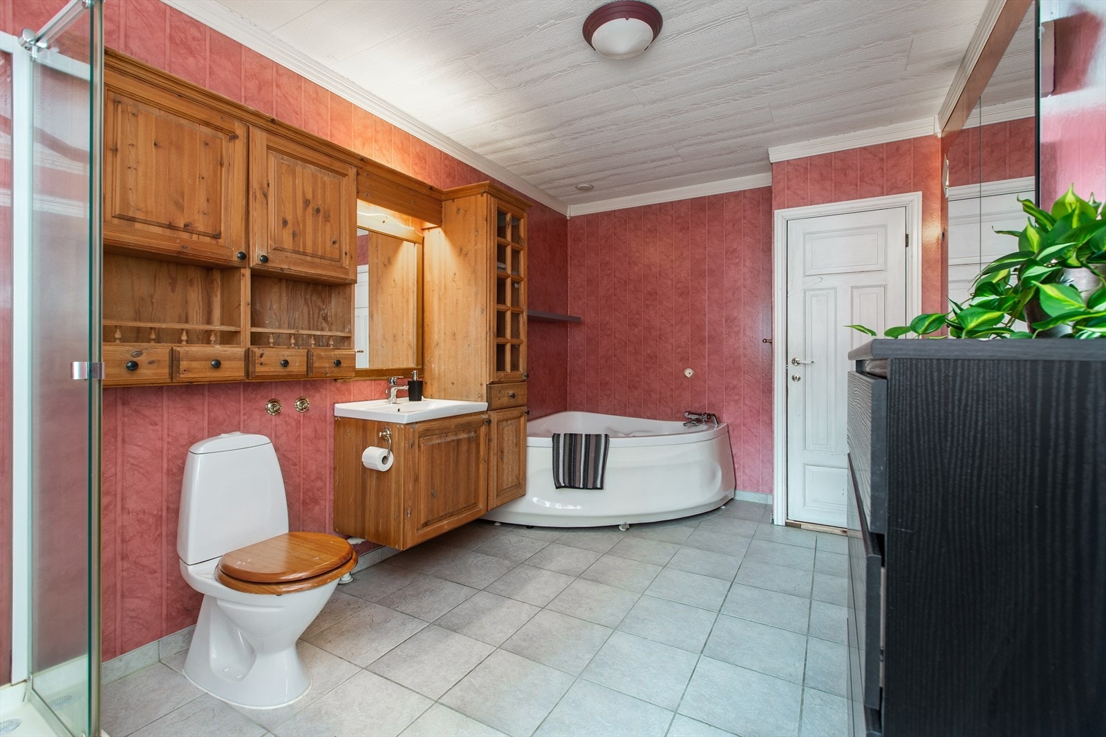 Stort bad med mye oppbevaring. Badet har både badekar og dusjkabinett, toalett og vask. Døren til høyre fører til hybel Galleribilde