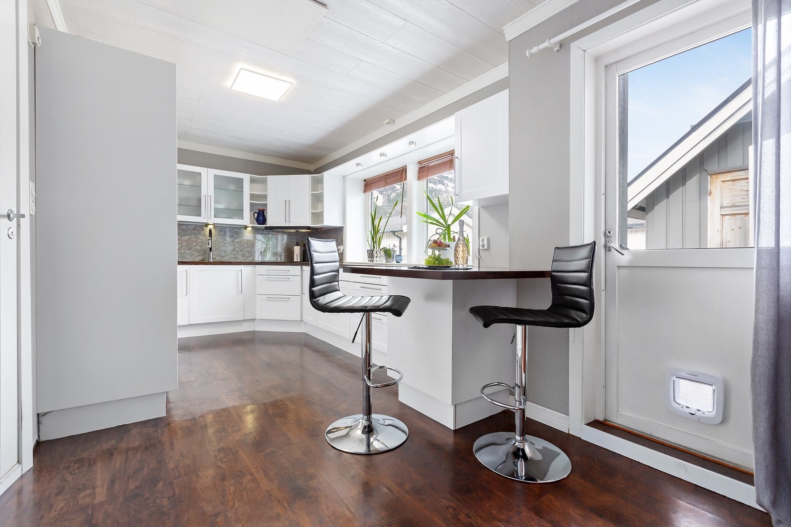 Lyst og pent kjøkken med praktisk barløsning Galleribilde