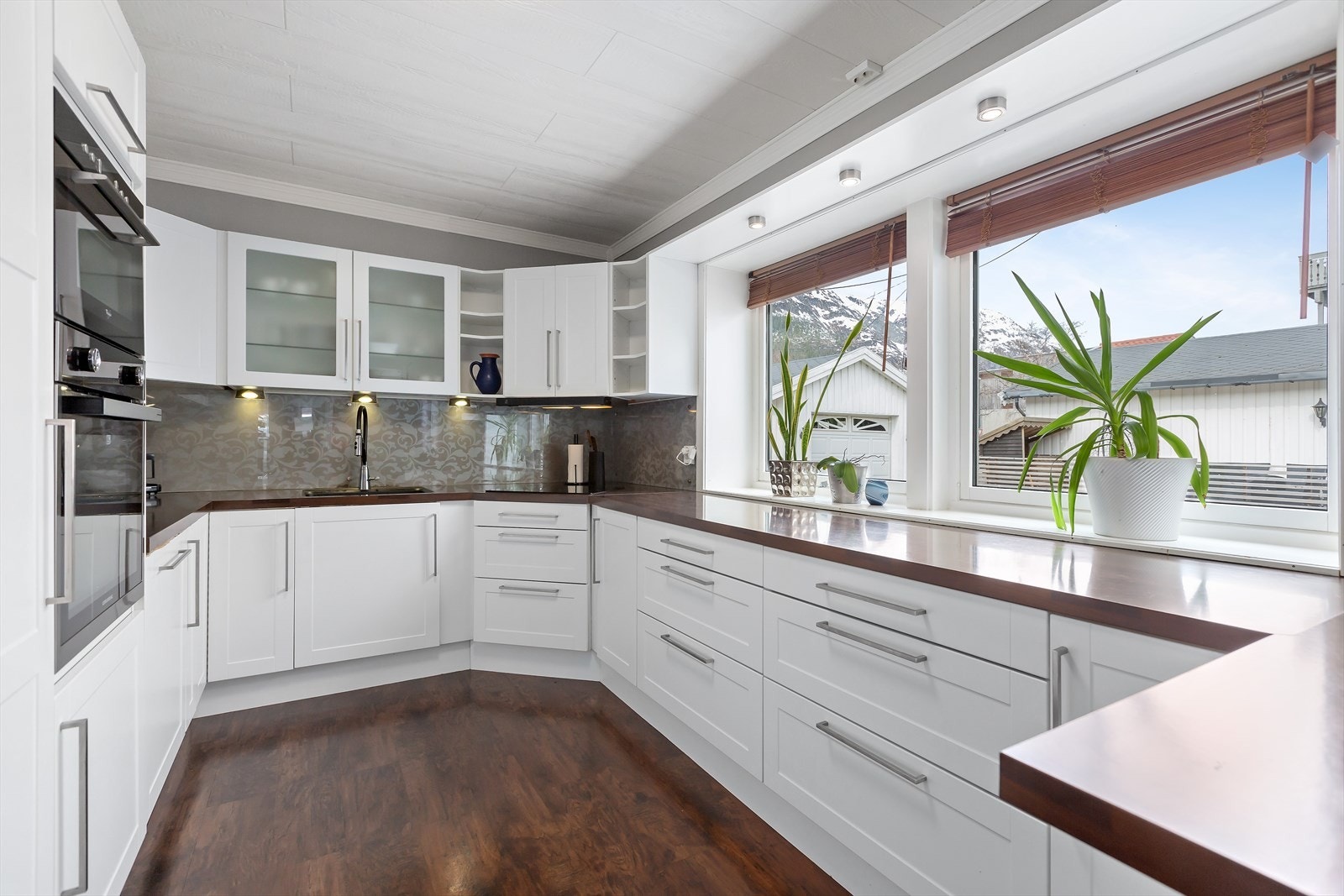 Stort kjøkken med hvite profilerte fronter og håndtak. Kjøkkenet er fra 2012 med allenødvendige hvitevarer integrert. Oppvaskmaskin og stekeovn er fra 2022. Galleribilde