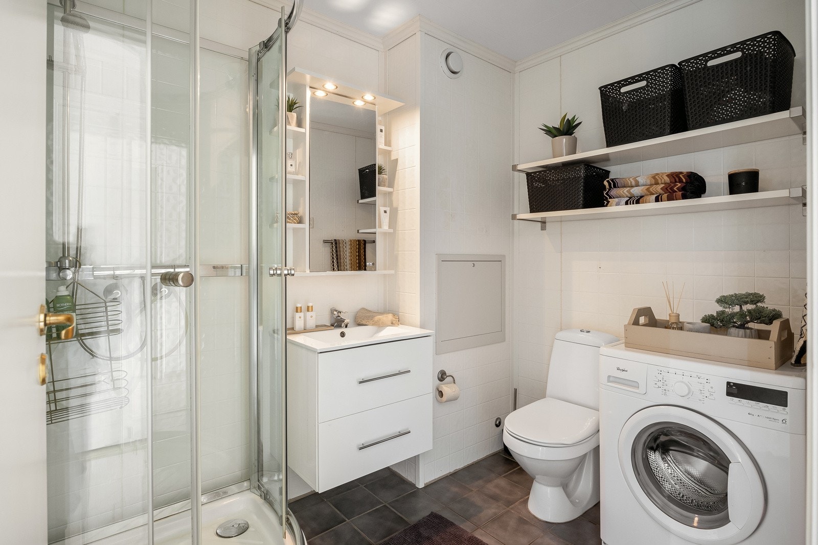 Badet er flislagt og utstyrt med varme i gulv, nyere baderomsinnredning, opplegg for vaskemaskin og dusjkabinett Galleribilde