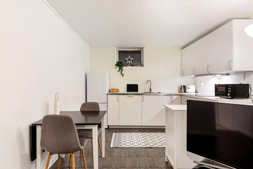 Kjelleretasjen har stue/kjøkken med plass for spisebord.