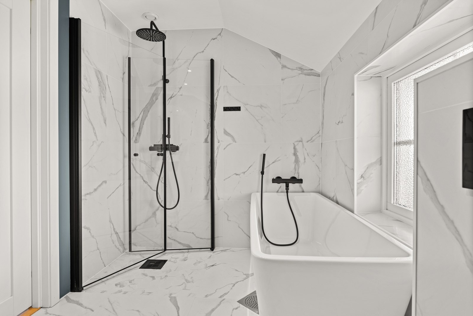 Baderommet er utstyrt med dusjnisje med regnfallsdusj, badekar, servant med innredning og vegghengt toalett Galleribilde