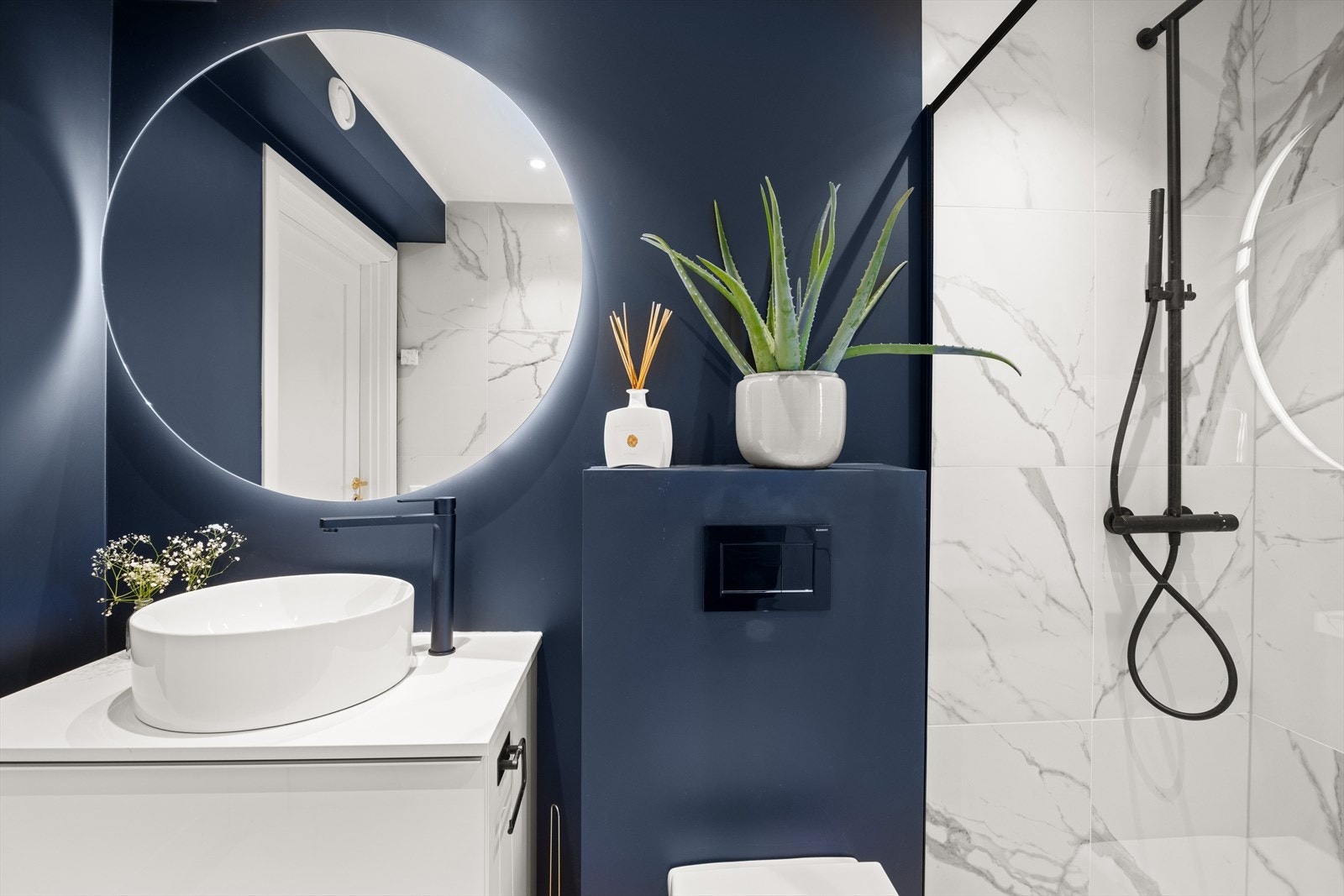 Baderommet er utstyrt med servant med innredning, speil, vegghengt toalett og dusjnisje med regnfallsdusj og glassvegg Galleribilde