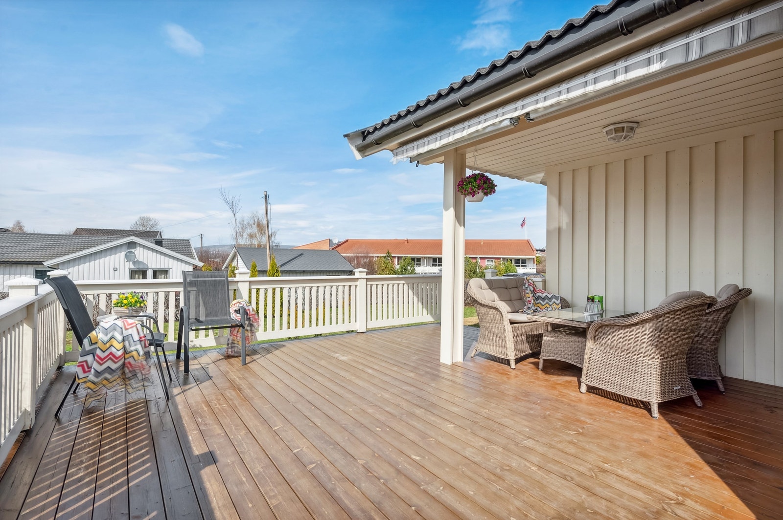 Stor og solrik terrasse som er delvis overbygget og med terrassemarkise Galleribilde