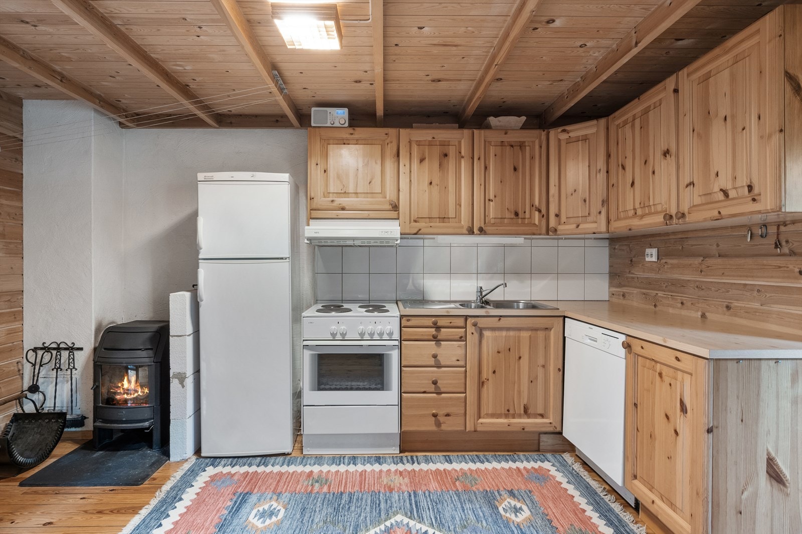 Kjøkkenet er plassert i en vinkelform og har både under- og overskap. Innredning har profilerte fronter og laminert benkeplate. Galleribilde