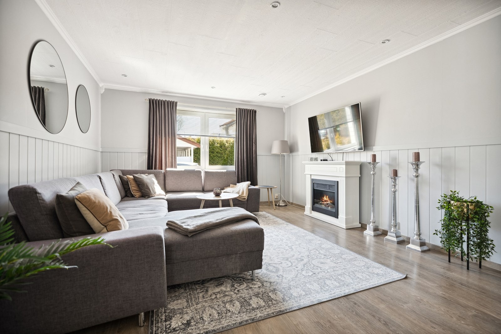 I stuen er det plass til både sofagruppe og spisebord. Overflatene er lysmalte og gulvet er belagt med vakker laminat. Galleribilde