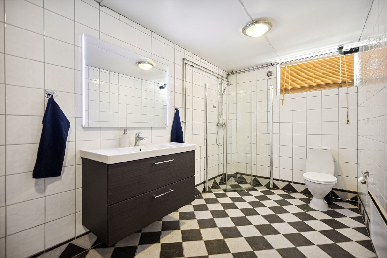 Stor flislagt bad oppusset i 2009, utstyrt med dusjhjørne med innfellbare glassvegger, gulvstående wc og servantinnredning med skuffer. Galleribilde