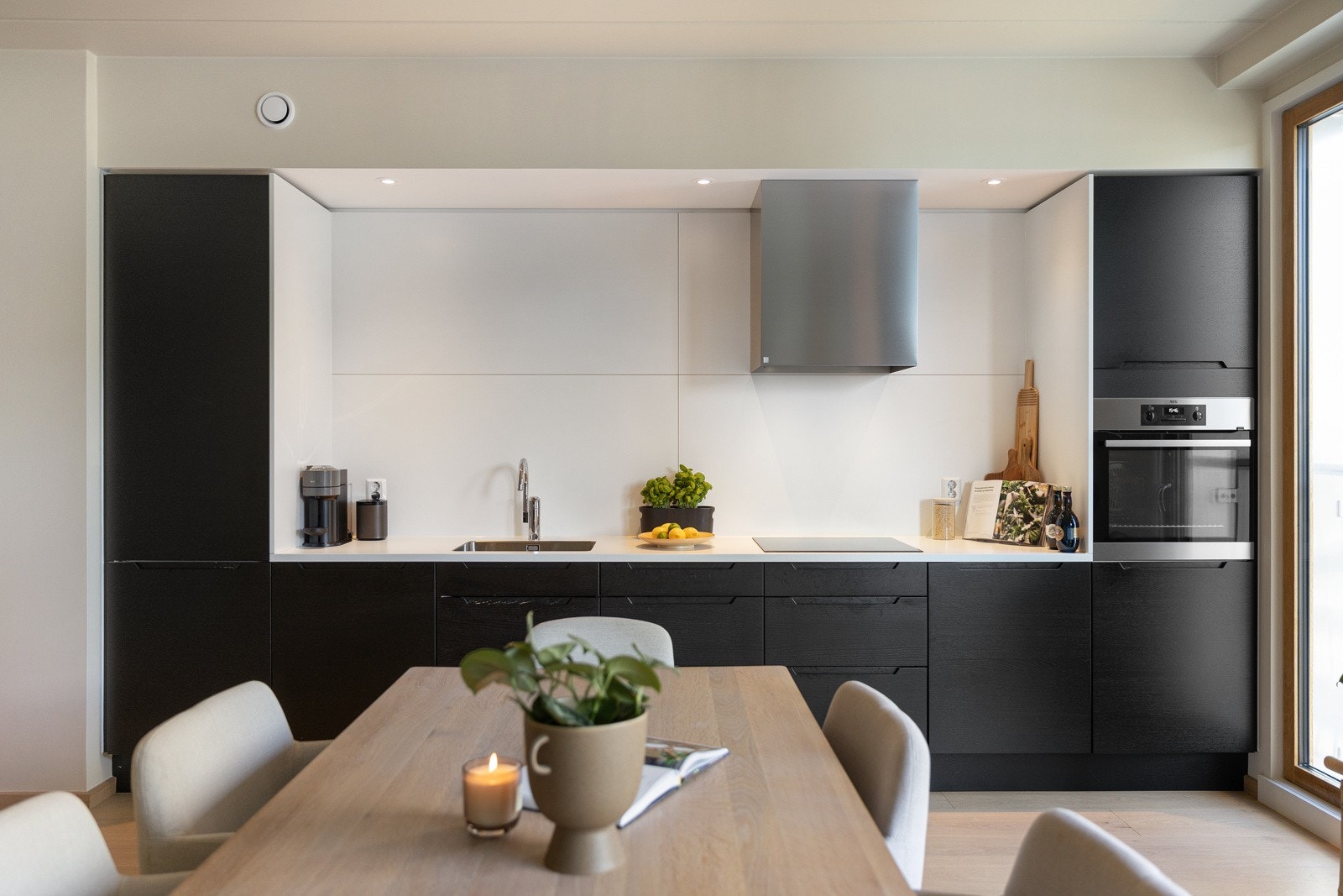 Lekkert og tidsriktig kjøkken fra HTH med glatte fronter og laminat benkeplate med kum i stål. Galleribilde