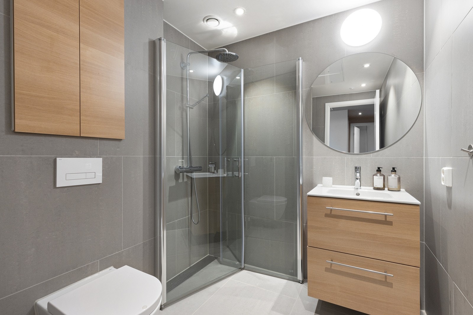 Delikat, flislagt baderom med praktisk adkomst fra entré. Galleribilde