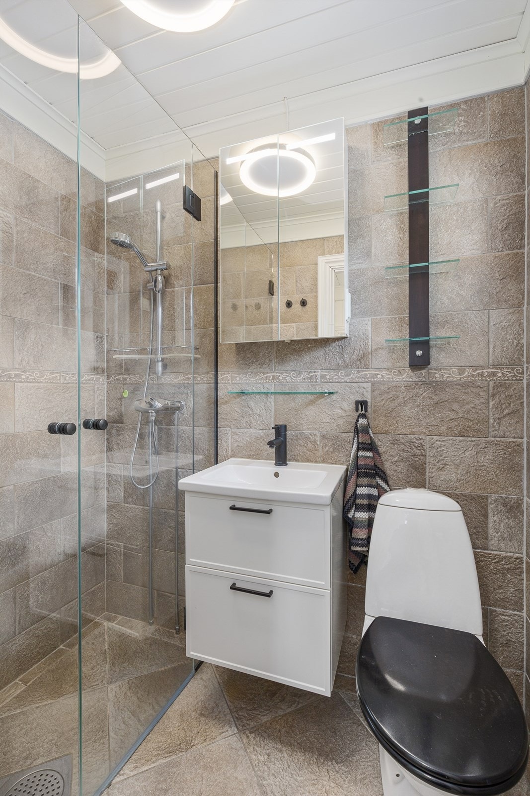 Badet har wc, servant i seksjon med speilskap over og stor dusjnisje. Galleribilde