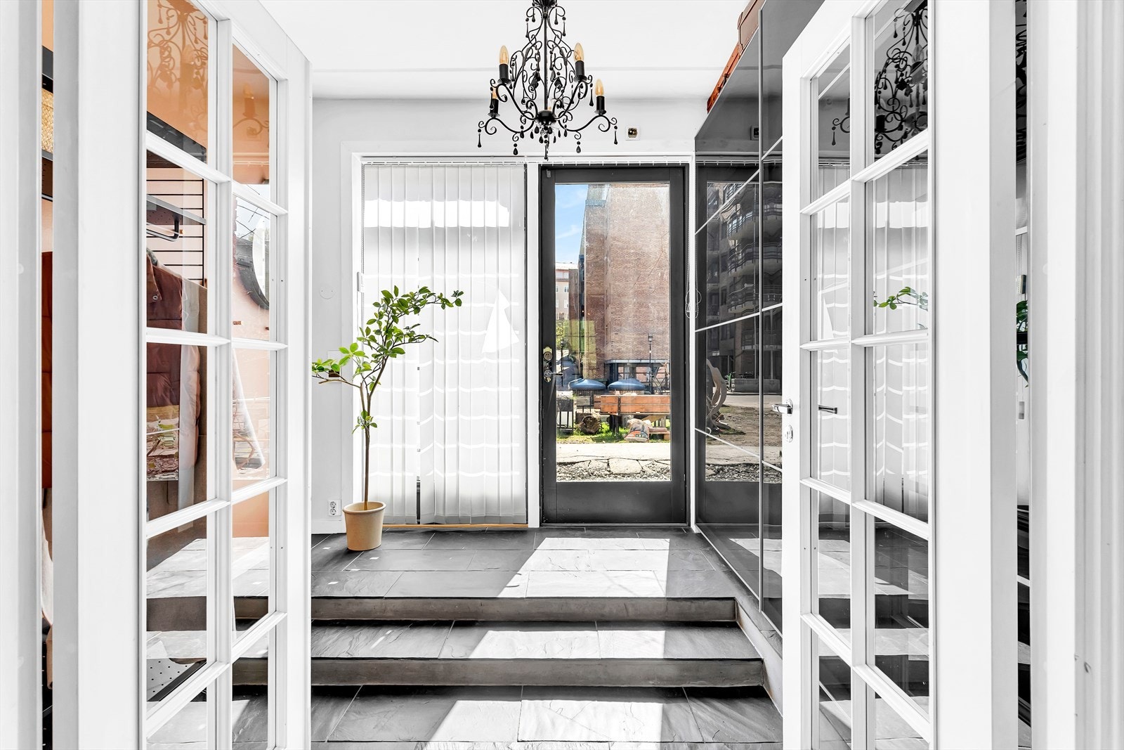 Lys og innbyende entré med flislagt gulv og stor skyvedørsgarderobe Galleribilde
