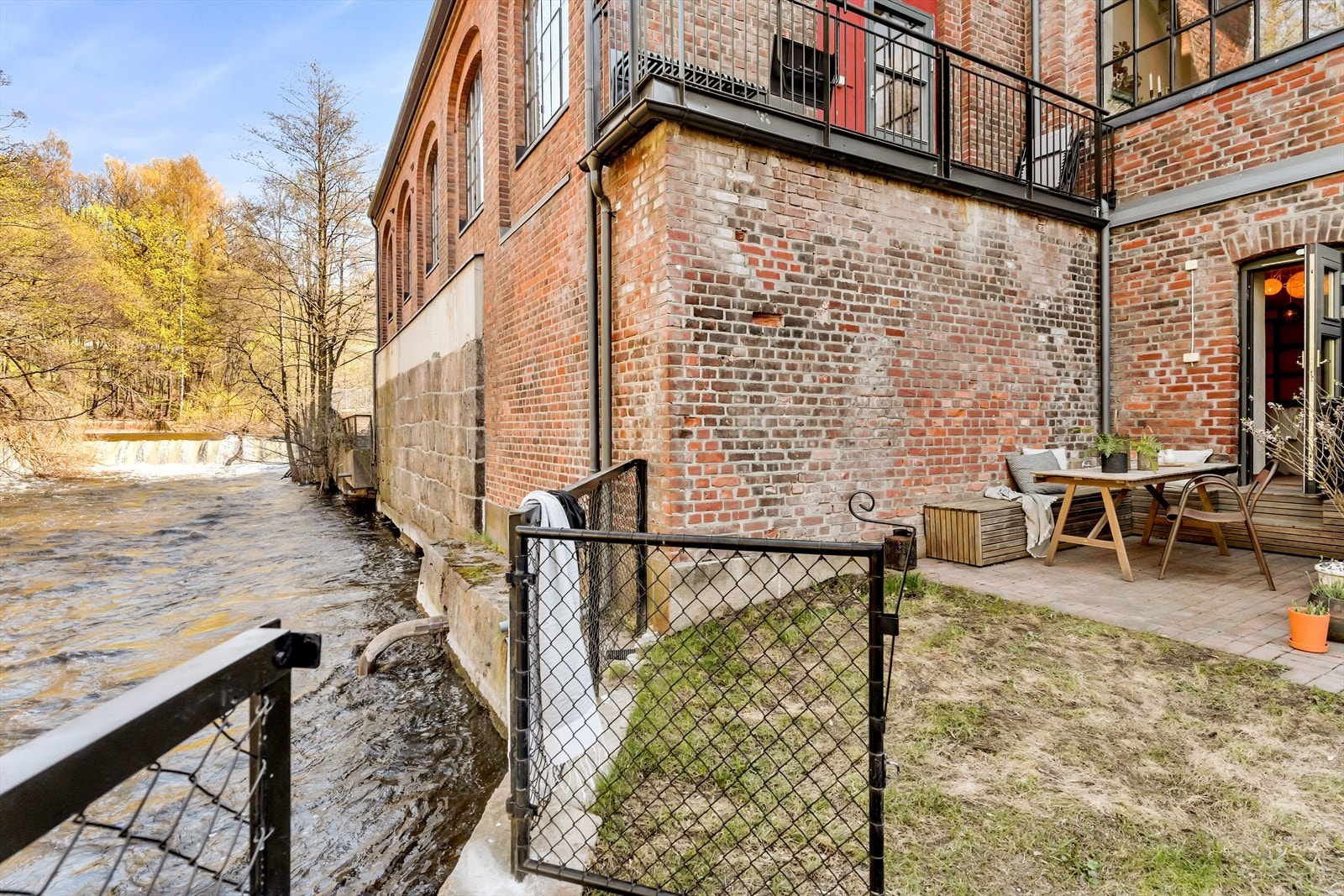 Direkte utgang fra boligen til en flott steinbelagt uteplass og plen. Galleribilde