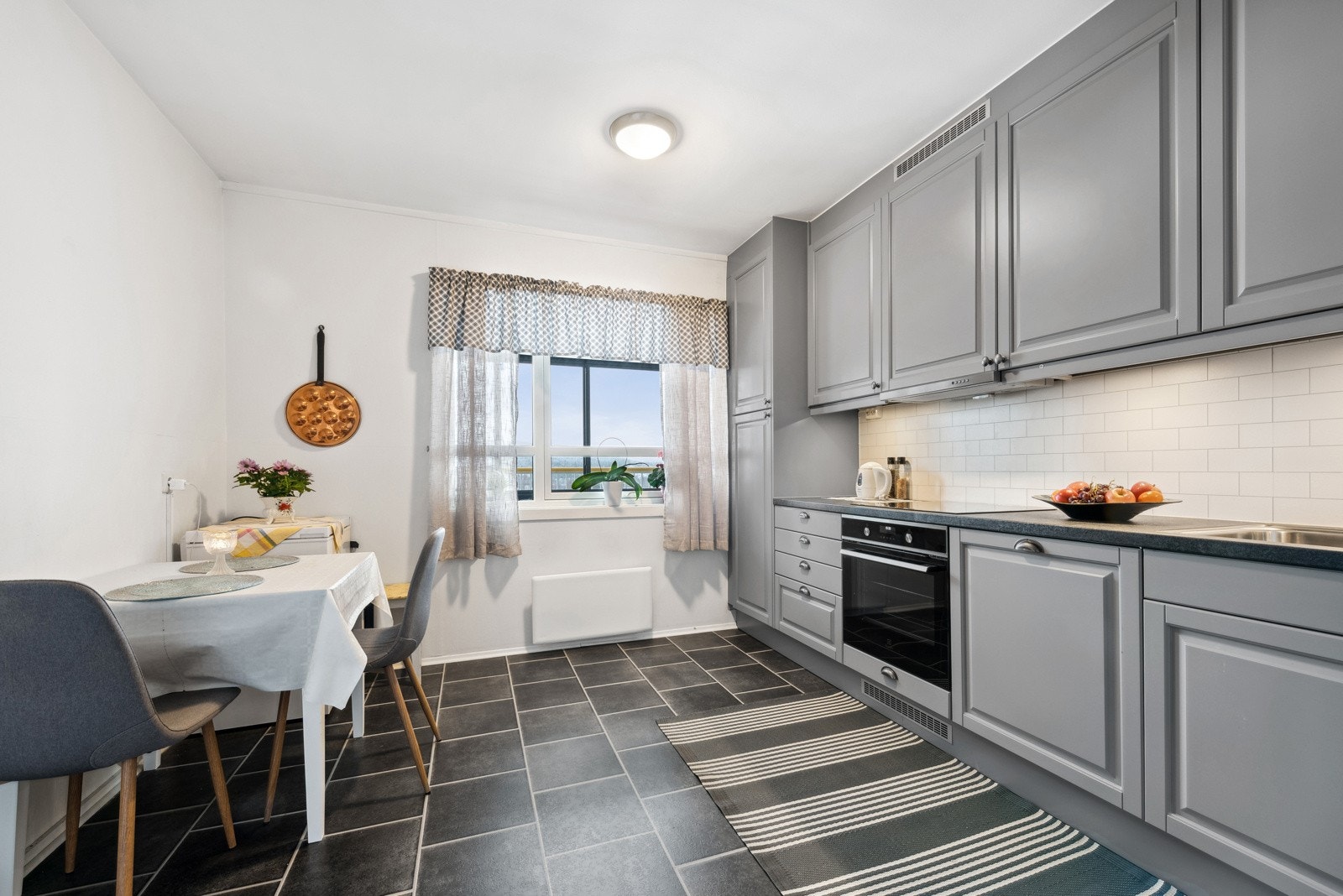 Leiligheten har et stort kjøkken med plass til spisebord. Galleribilde