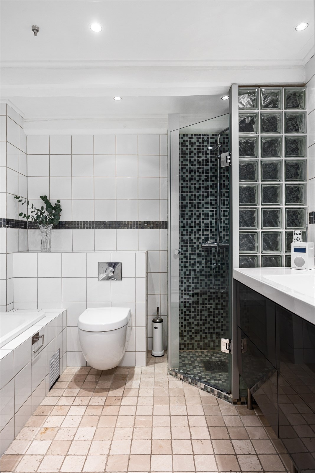 Pent, flislagt baderom som består av bl.a. dusjhjørne, innfliset badekar og vegghengt toalett. Galleribilde