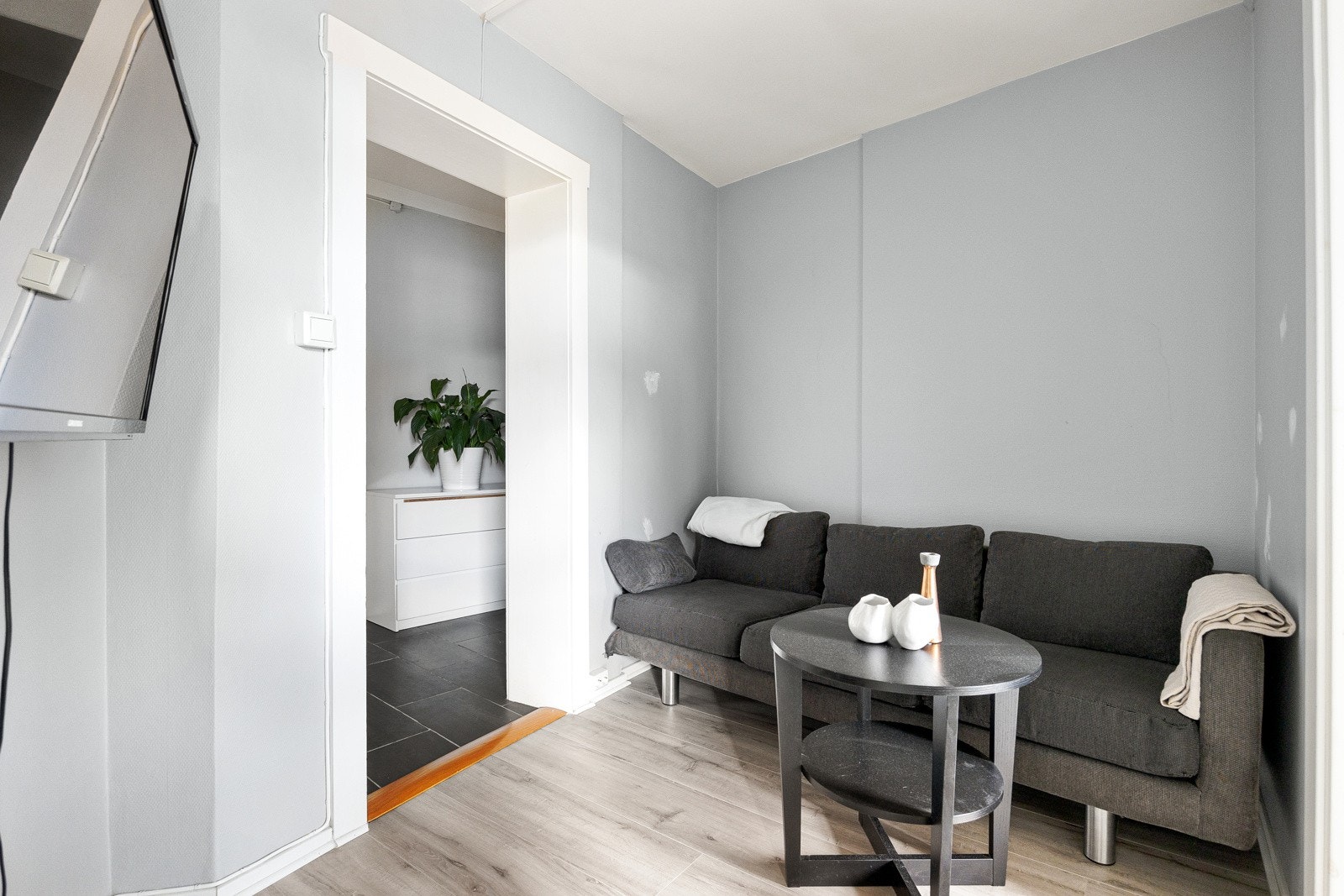 Stue med lyse overflater og laminat gulv fra 2021. Det er god plass til sofa og TV. Galleribilde