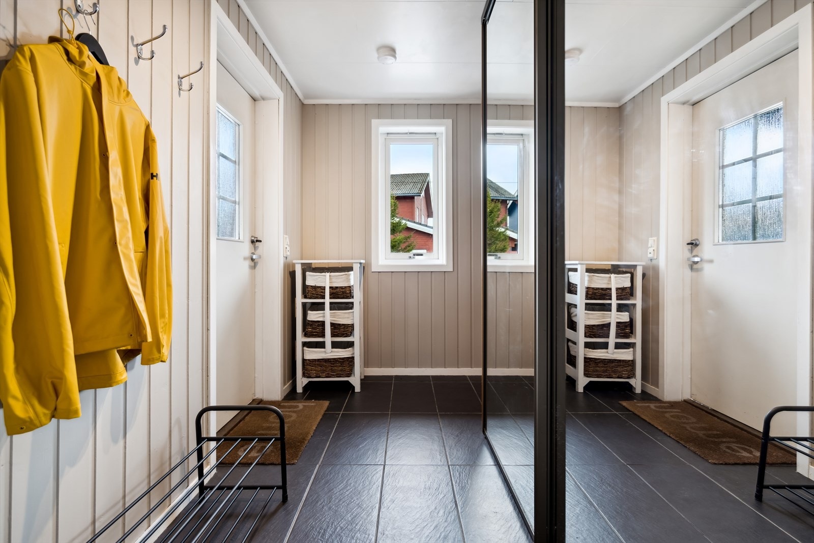 Med skyvedørsgarderobe, knaggrekker og skohylle har du god plass til oppbevaring av yttertøy og sko Galleribilde