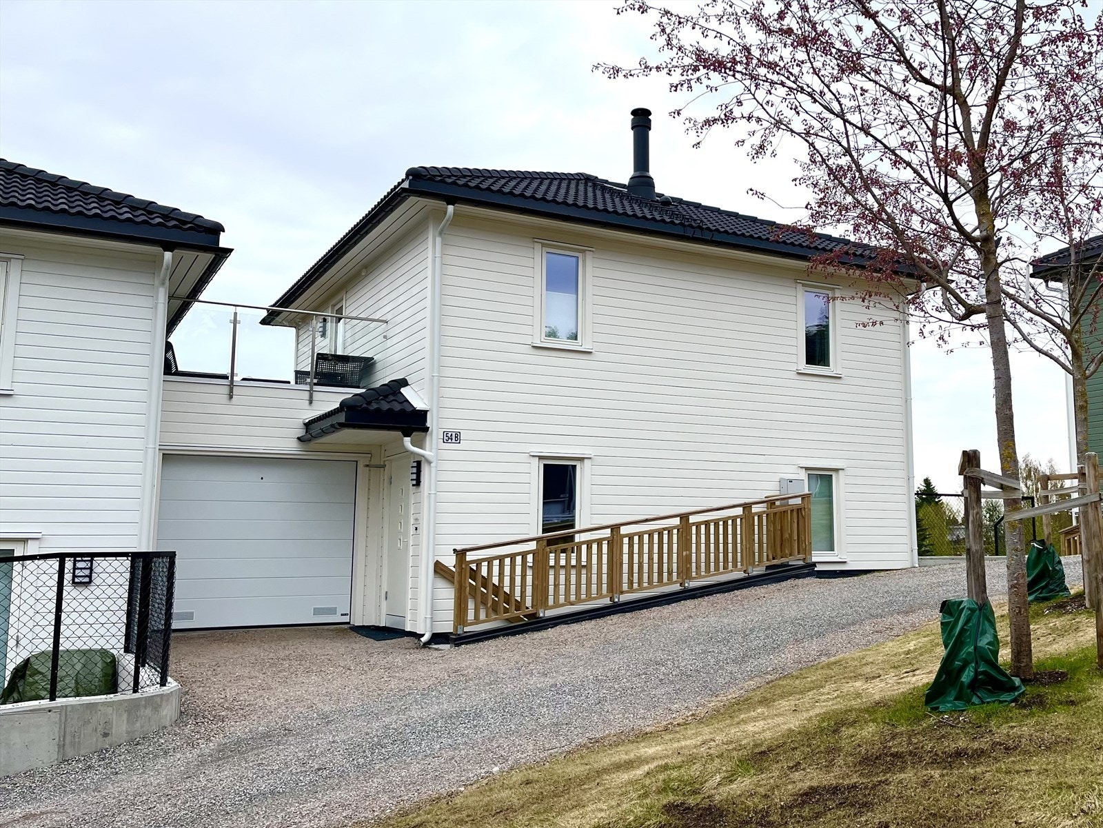 To innganger i huset og garasje med lader til elbil. Galleribilde