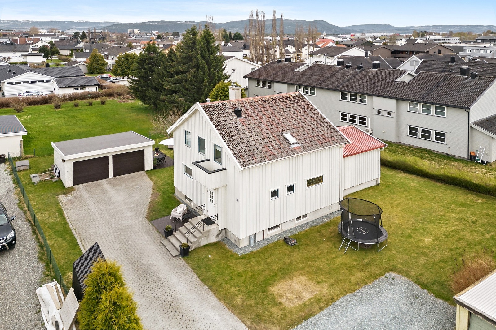Eiendommen er fint opparbeidet med en romslig hage, brosteinbelagt gårdsplass, dobbelgarasje og ekstra gruslagt parkeringsplass. Galleribilde