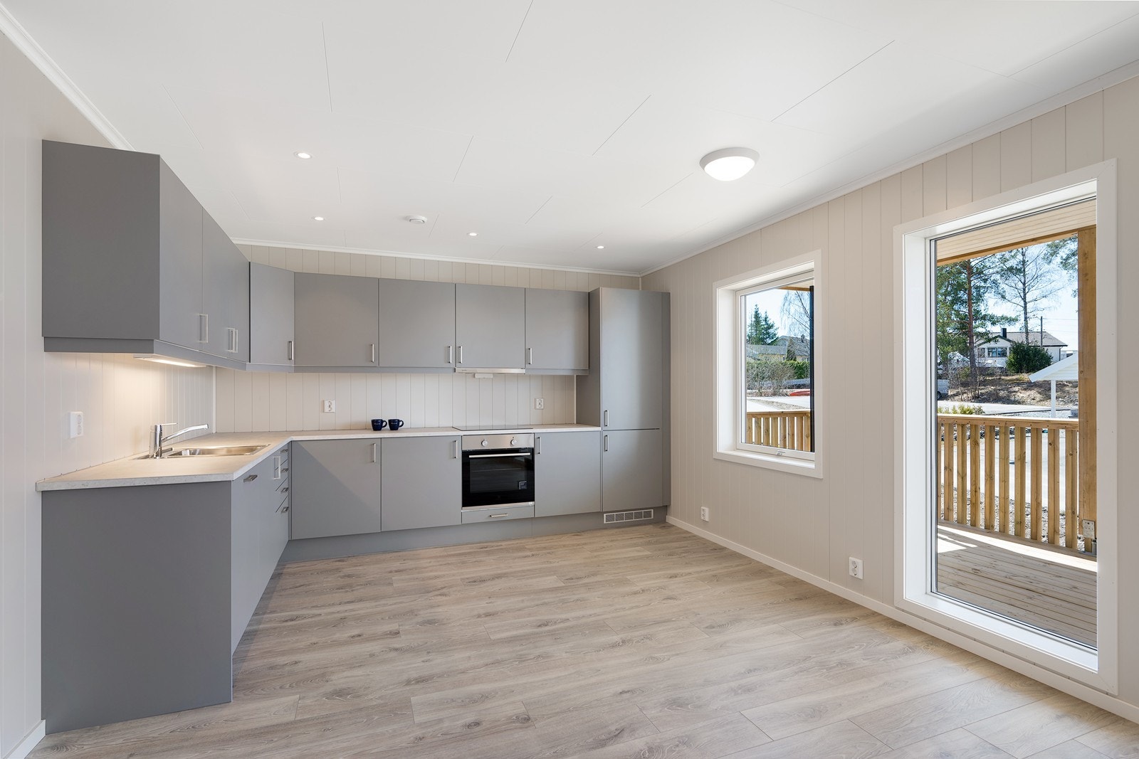 En lekker innredning med grå, glatte fronter og laminert benkeplate. Galleribilde