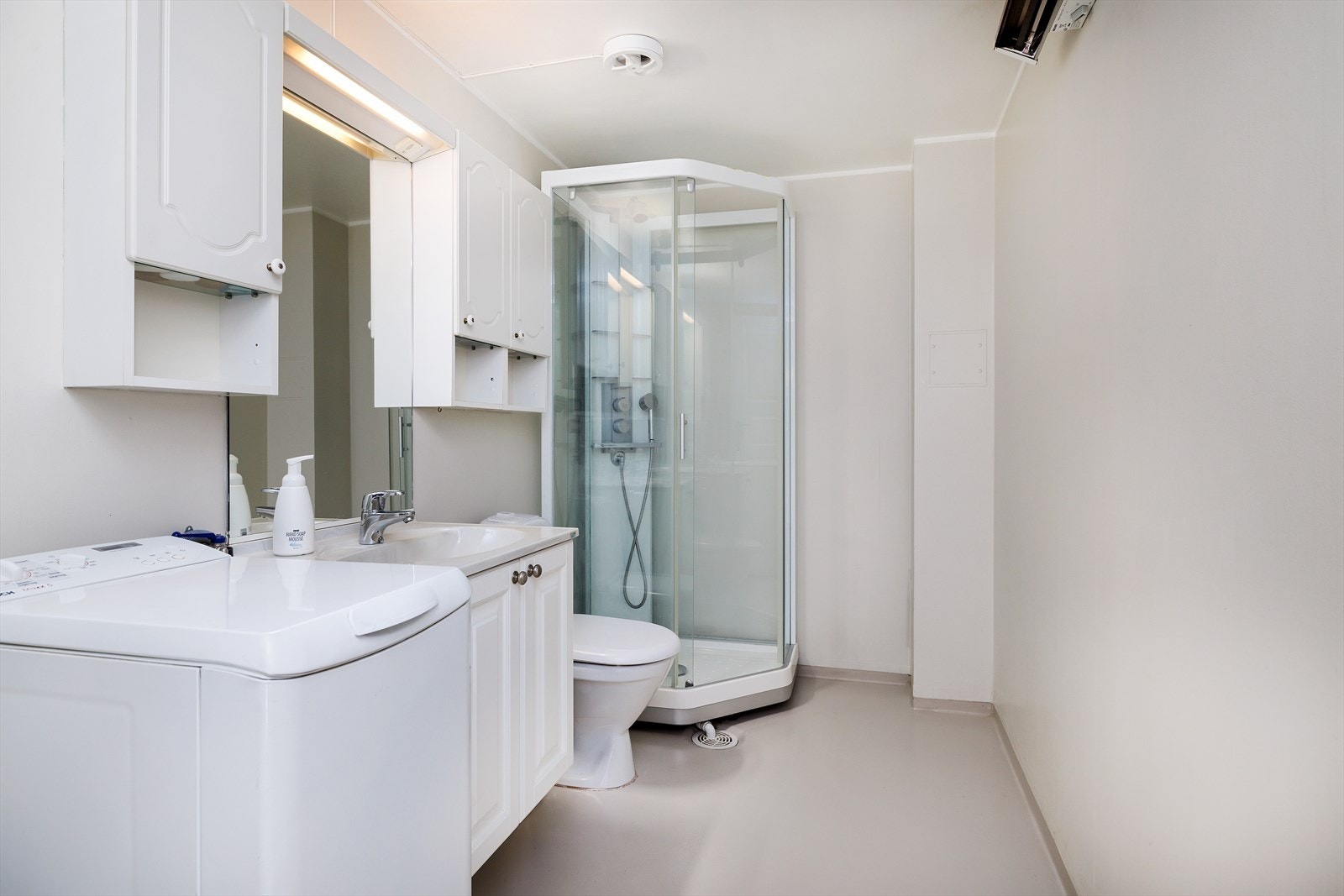 Romslig bad/vaskerom med opplegg for vaskemaskin. Galleribilde