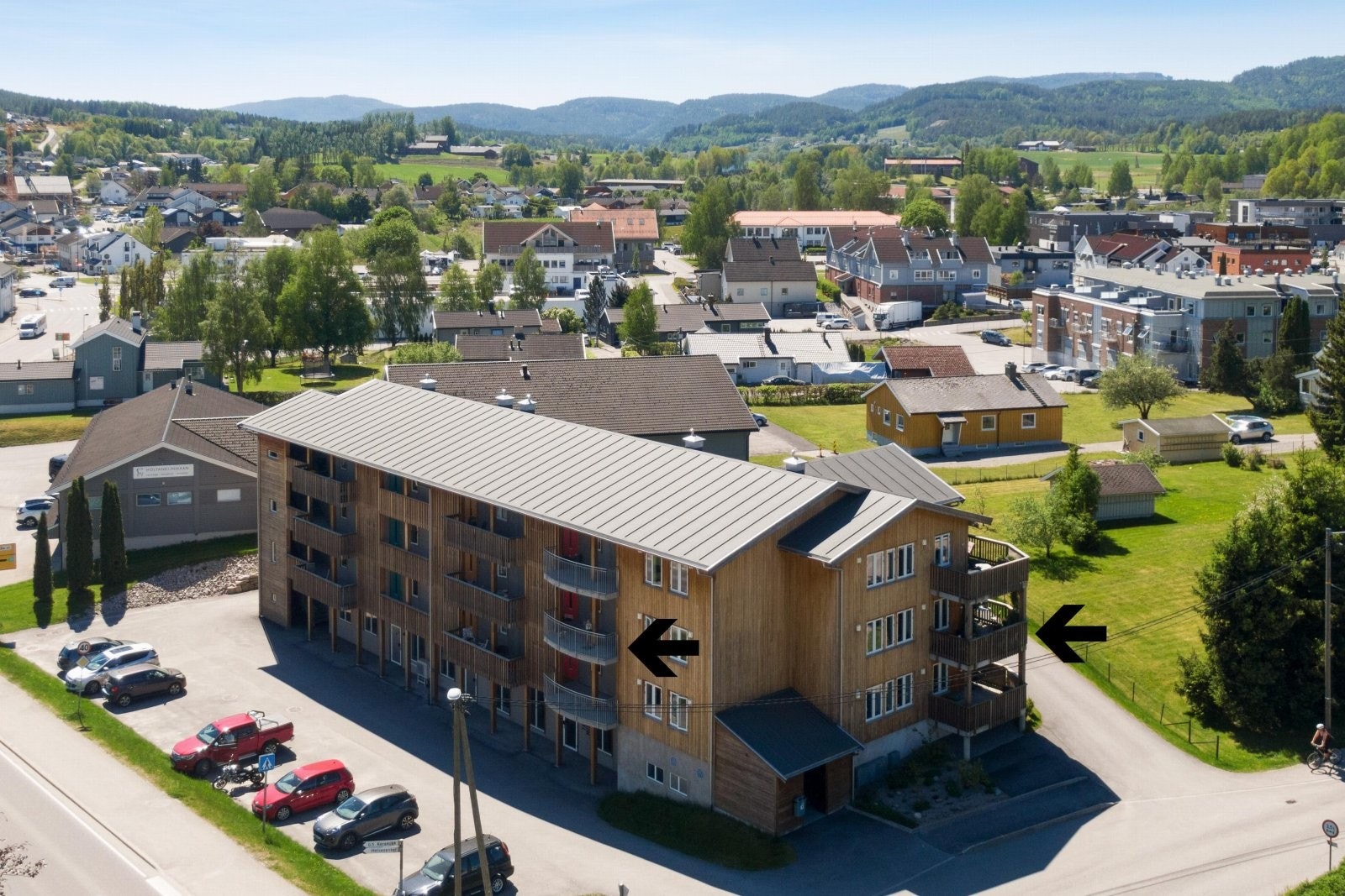 - Bilde sett fra Folkestadvegen/Gamleveg. Felles parkeringsplass ute. Balkongene er merket med svarte piler - Galleribilde